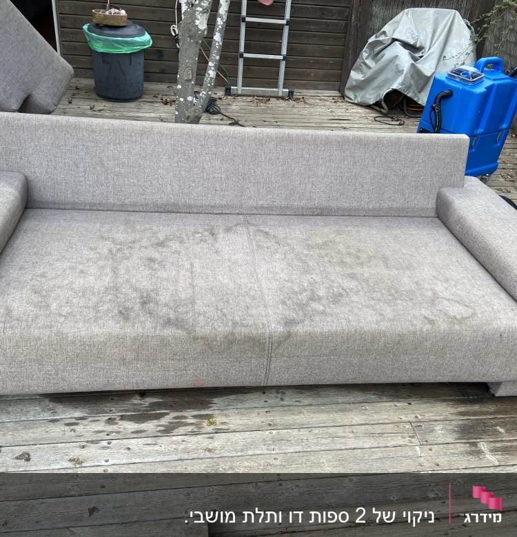 ספה אפורה עם כתמים על משטח עץ